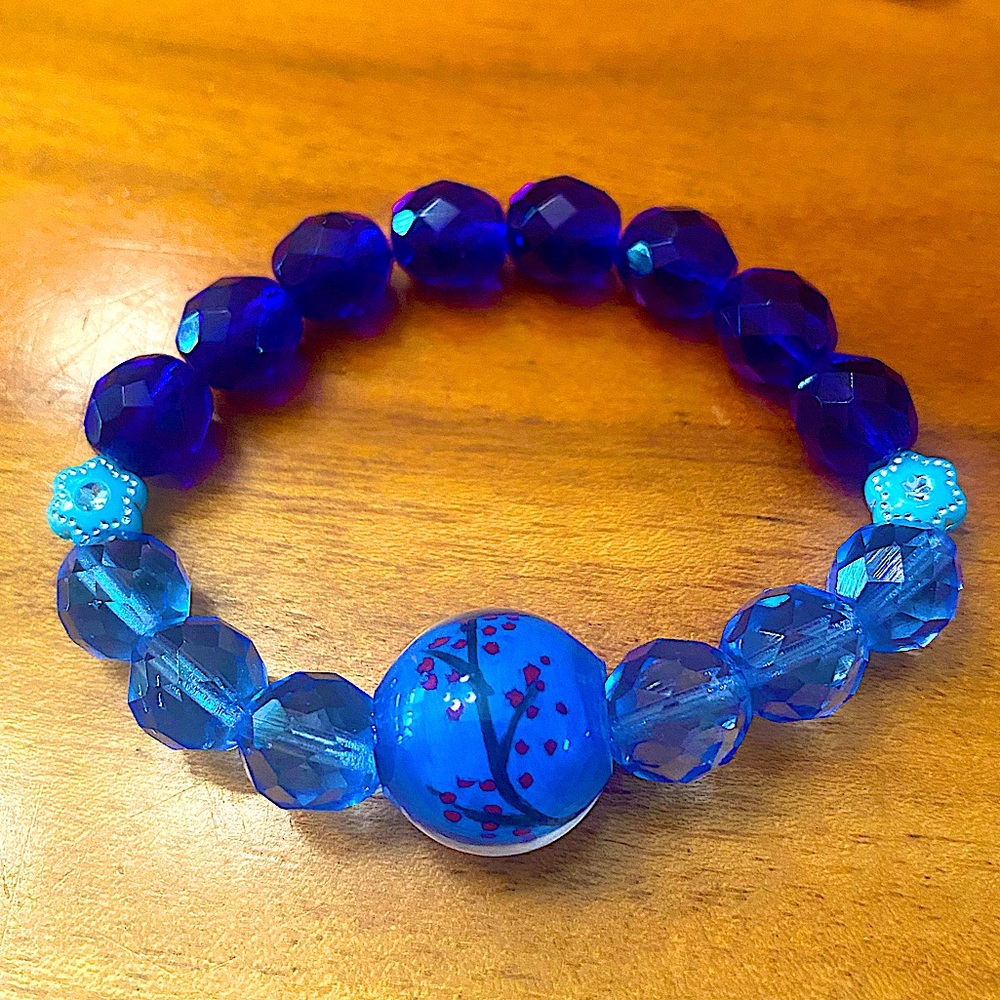 Bracelet bleu avec fleurs. Entre 15cm et 17cm.